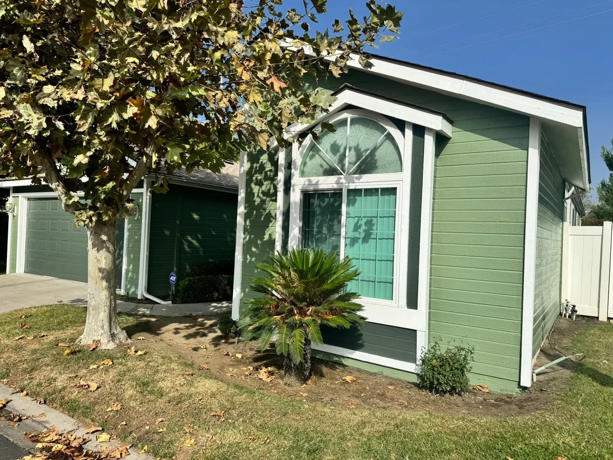 Green exterior house paint with white trim accents
