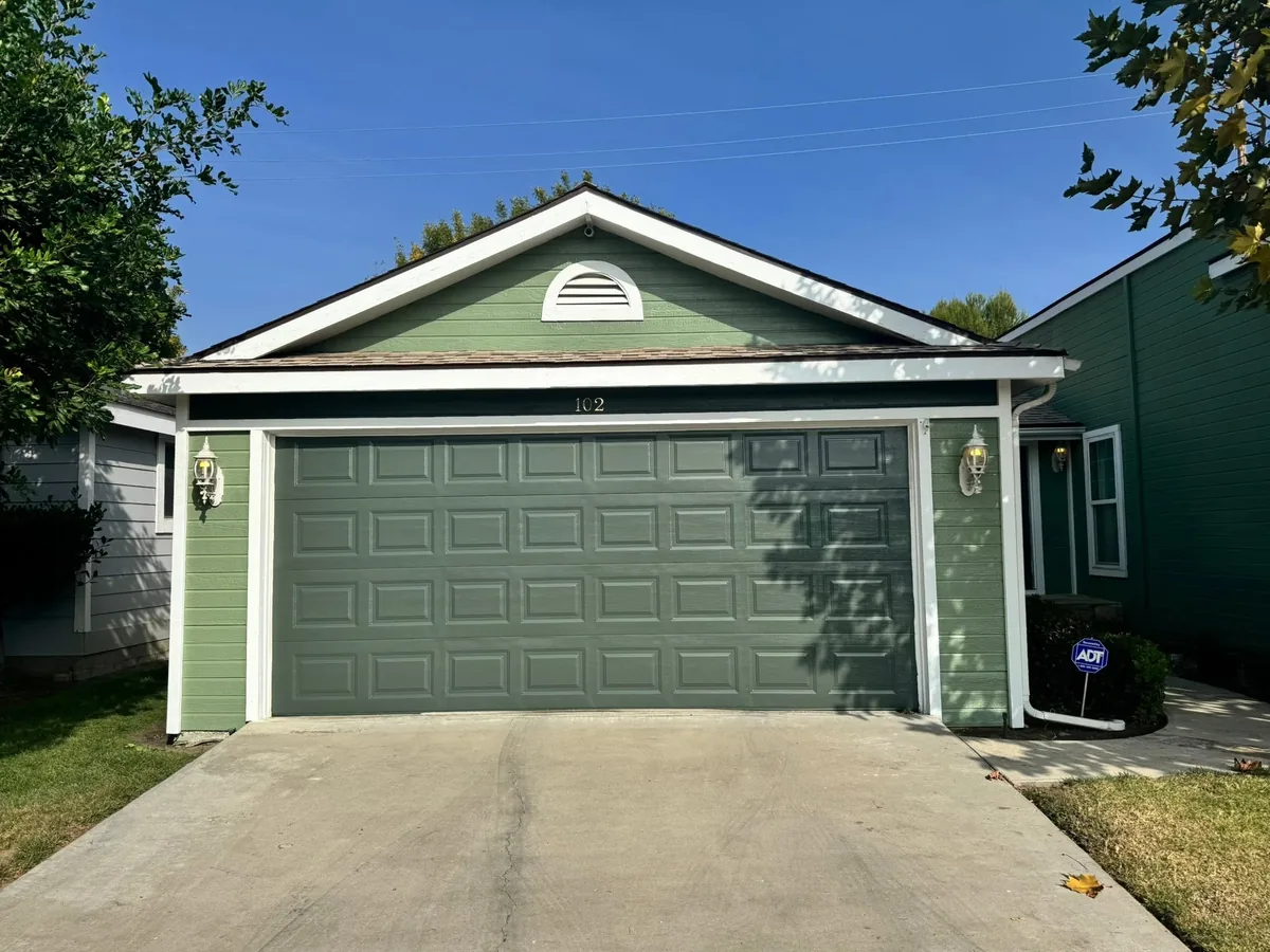 Green painted siding and garage door on a home exterior